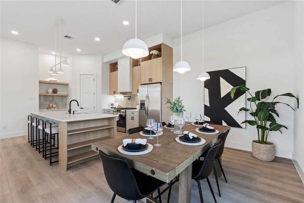 Thoughtfully designed with clean lines and elevated finishes, this kitchen-dining combo features custom flat-panel cabinetry, soft-close drawers, quartz countertops, and a spacious island with waterfall detail—bathed in natural light from oversized energy-efficient windows.